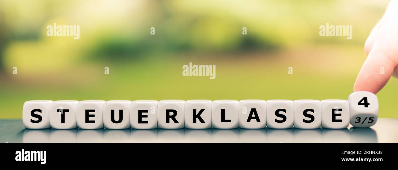 Simbolo per la modifica della classe fiscale 3/5 a 4 in Germania. Mano gira cubo e cambia l'espressione tedesca "Steuerklasse 3/5" (classe fiscale 3/5) in "Steue Foto Stock