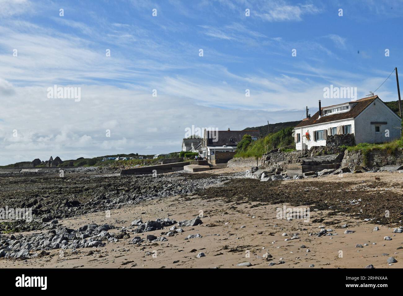 Parte della spiaggia di Port Eynon sulla Penisola di Gower (AONB) in agosto mostra l'ostello bianco YHA e altre case, così come il Salthouse Foto Stock