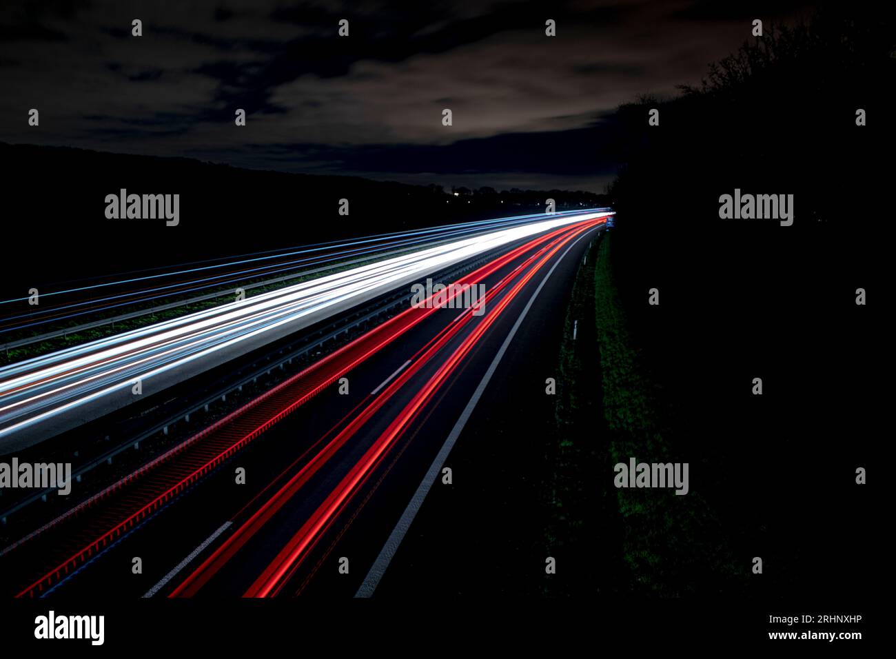Lunga esposizione su un'autostrada in germania di notte, piste luminose dai colori freddi Foto Stock