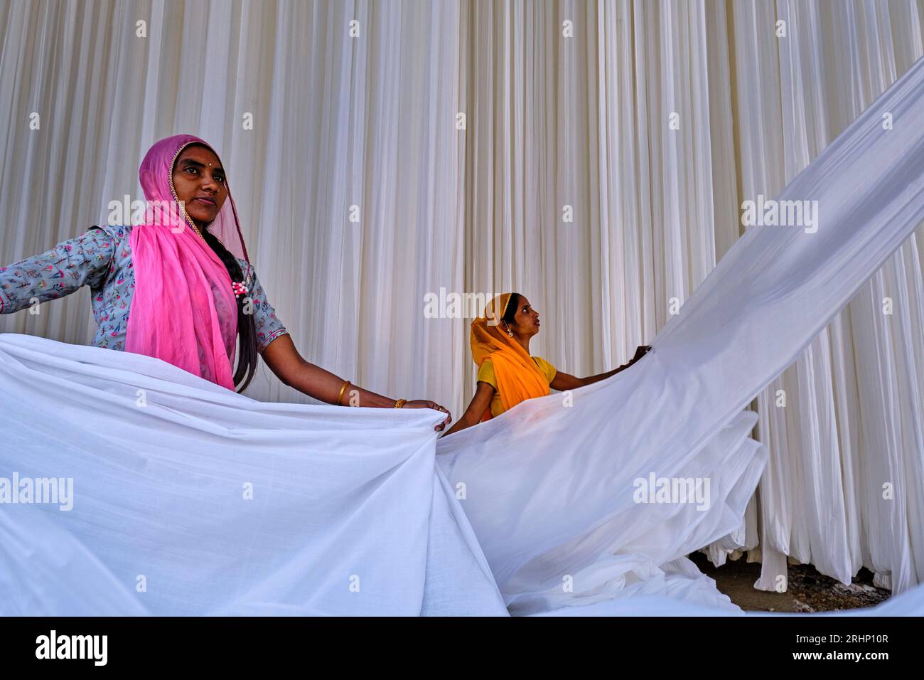 India Rajasthan, Sari fabbrica tessile sono asciugati all'aria aperta. La raccolta del prodotto tessile secco vengono piegate per le donne Foto Stock