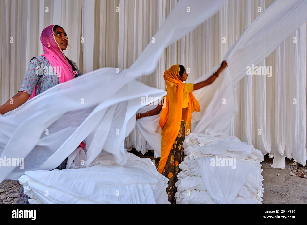 India Rajasthan, Sari fabbrica tessile sono asciugati all'aria aperta. La raccolta del prodotto tessile secco vengono piegate per le donne Foto Stock