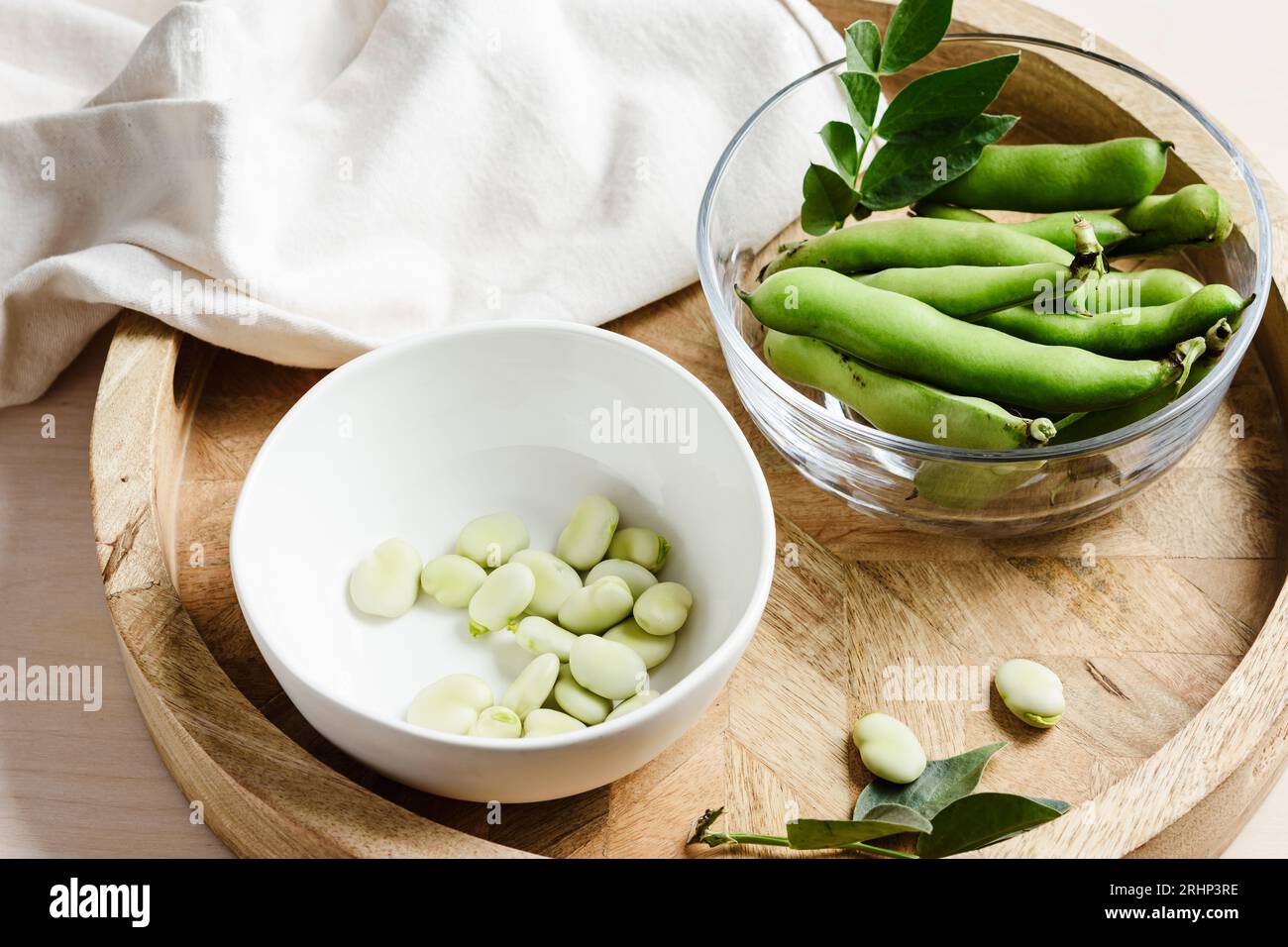 Ciotola di fave verdi su un vassoio di legno Prodotti vegani. Foto Stock