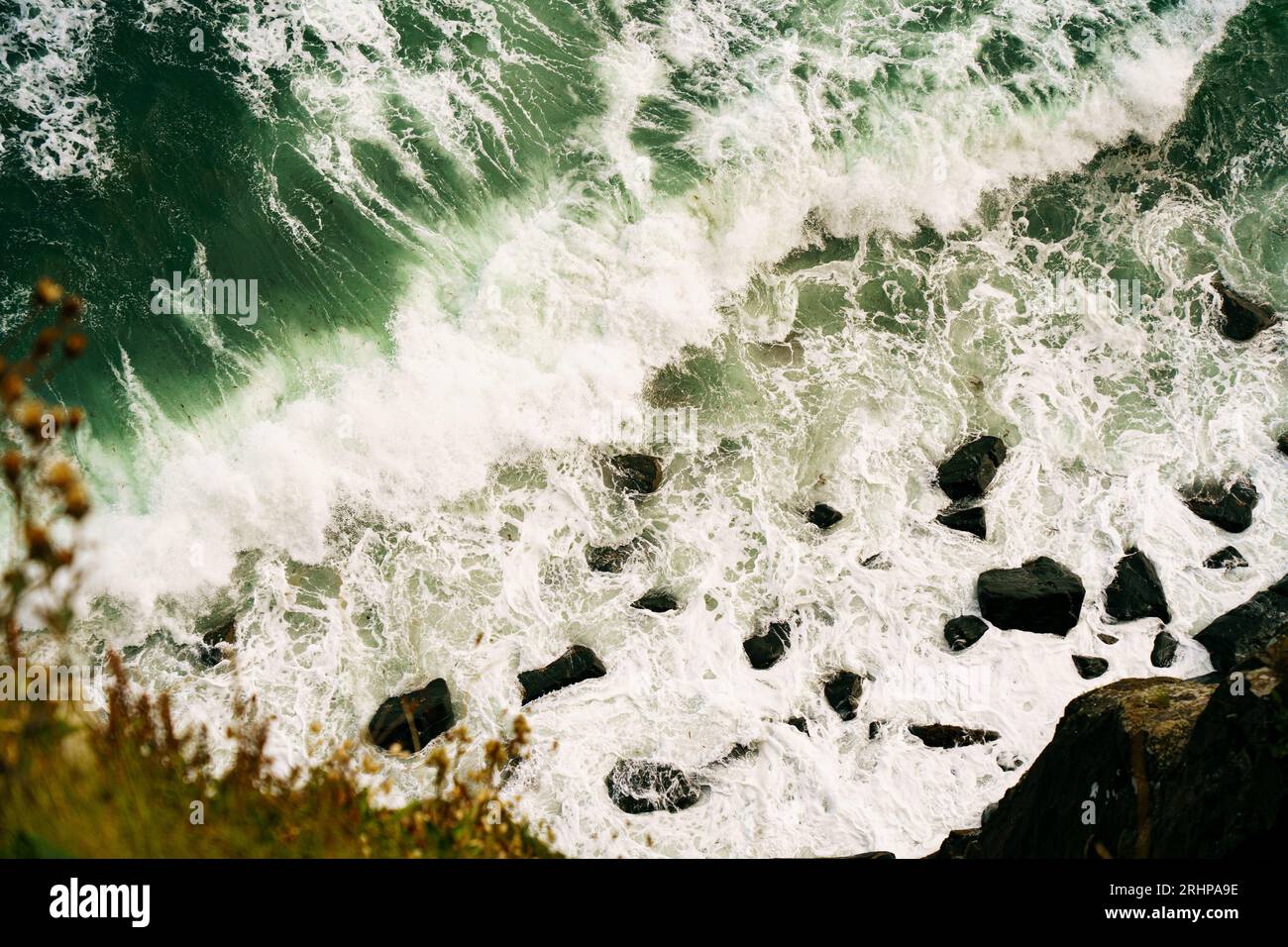 vista dall'alto delle onde d'acqua che si infrangono sulla costa rocciosa Foto Stock