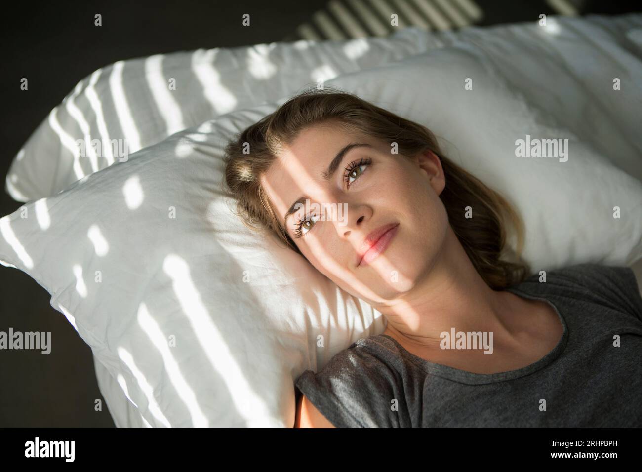 Giovane donna a letto Foto Stock
