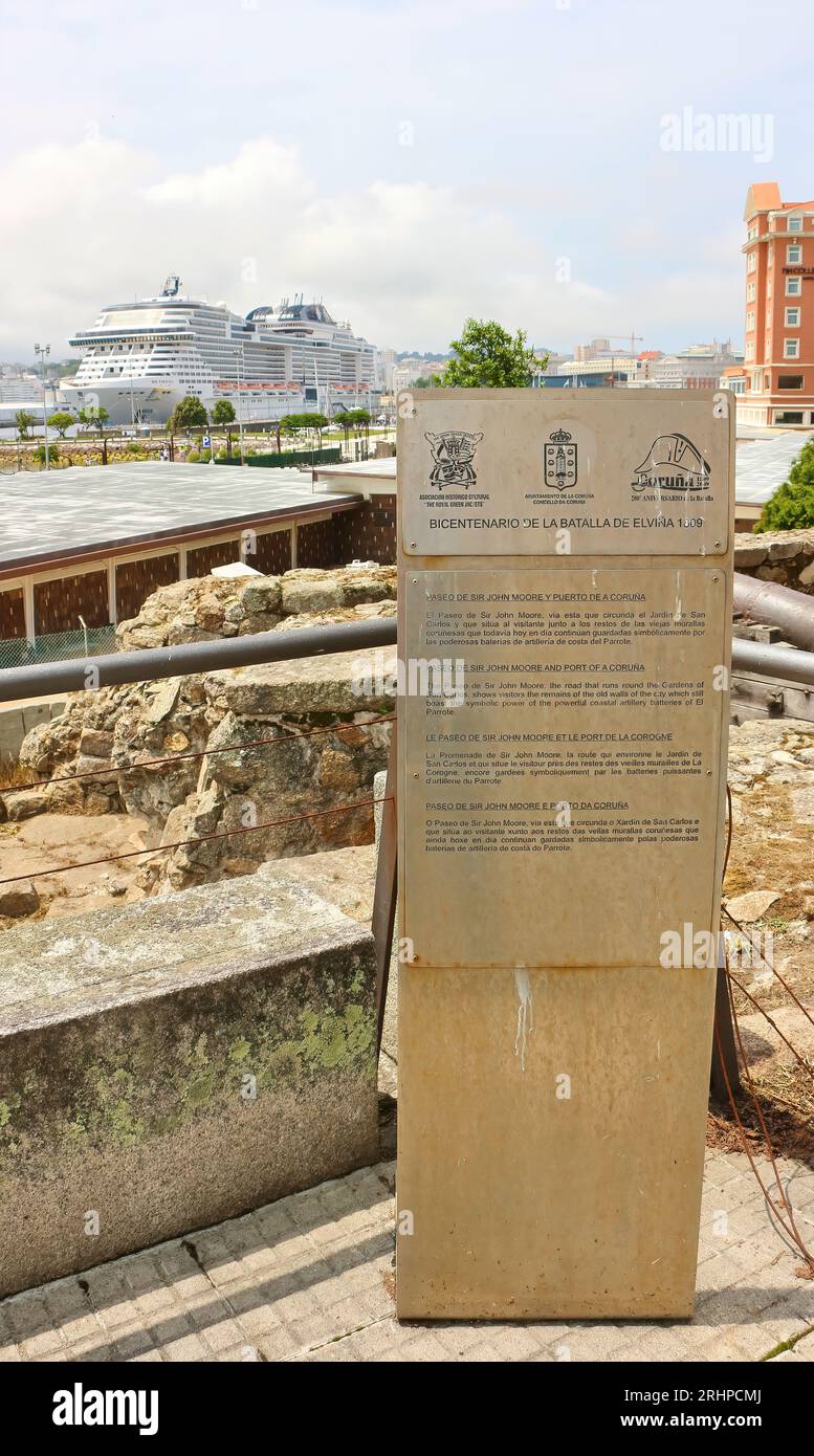 Vista sul paesaggio con un cartello turistico presso le mura della città vecchia e la nave da crociera MSC Virtuosa in lontananza nel porto A Coruña Galizia Spagna Foto Stock