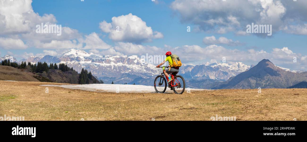 Italia, Veneto, provincia di Belluno, Selva di Cadore, Dolomiti, donne di 45 anni in e-bike / e-mtb su un sentiero di montagna Foto Stock