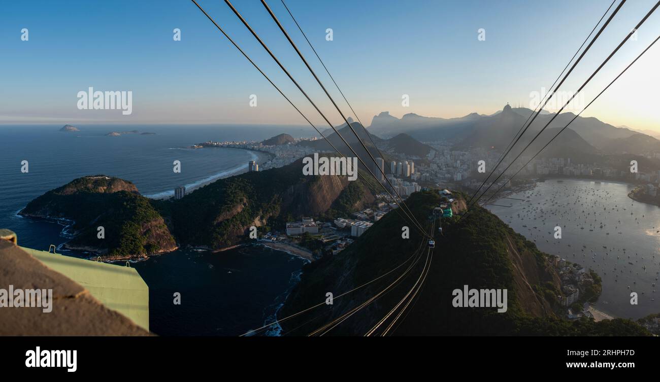 Rio de Janeiro, Brasile: La funivia del Pan di zucchero e la splendida vista panoramica dello skyline della città con montagne, spiagge e quartieri Foto Stock