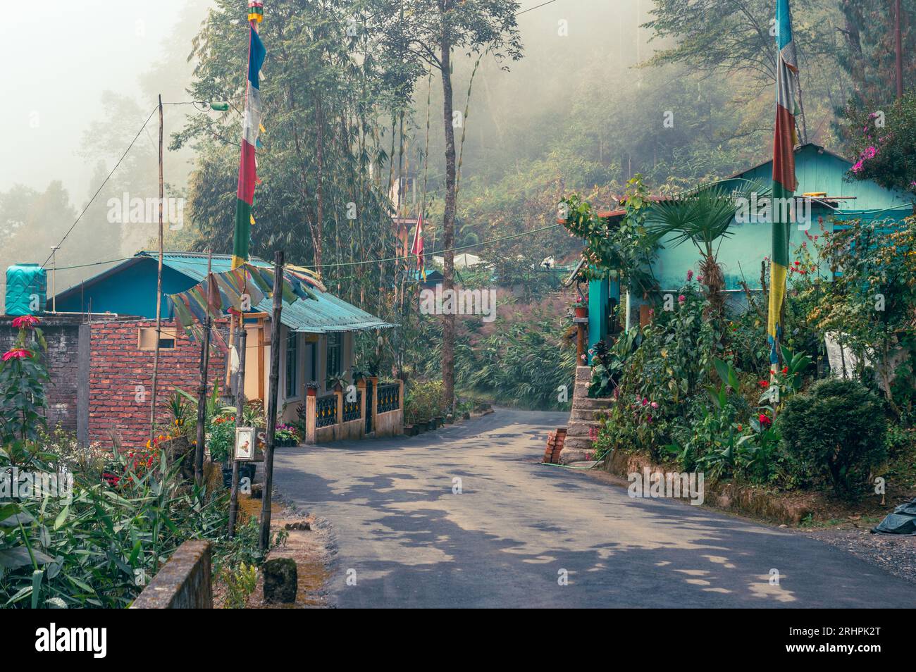 Un bel rifugio di montagna accanto ad una strada asfaltata che conduce attraverso la foresta nebbiosa sullo sfondo. Tagda Mirik Darjeeling Bengala Occidentale India Sud AS Foto Stock