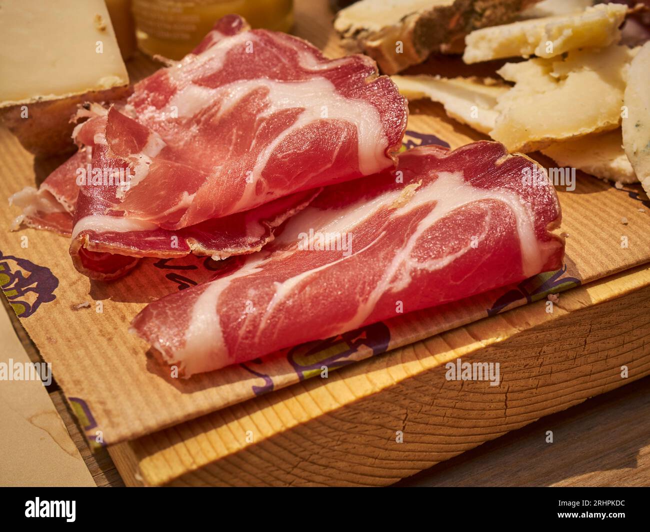 Tagliere di salumi con prosciutto e fette di formaggio servito a Cuneo, Piemonte, Italia Foto Stock