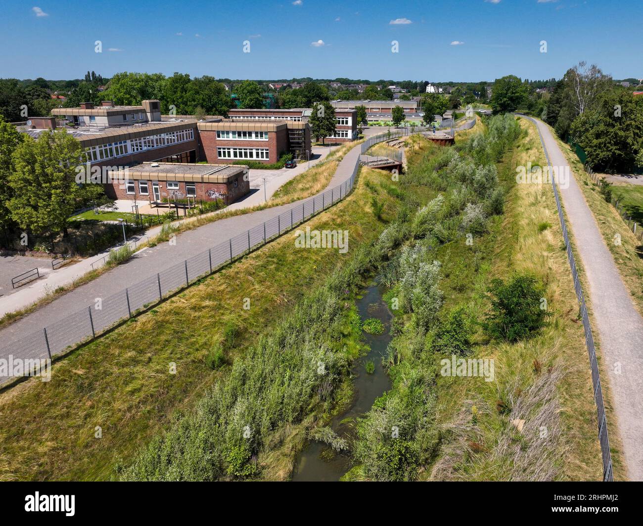 Recklinghausen, Renaturalized Hellbach, Germania - Käthe Kollwitz Comprehensive School. Corso d'acqua rinaturalizzato Foto Stock