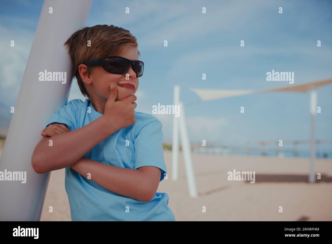 Ritratto di bel ragazzo con occhiali da sole sulla spiaggia Foto Stock