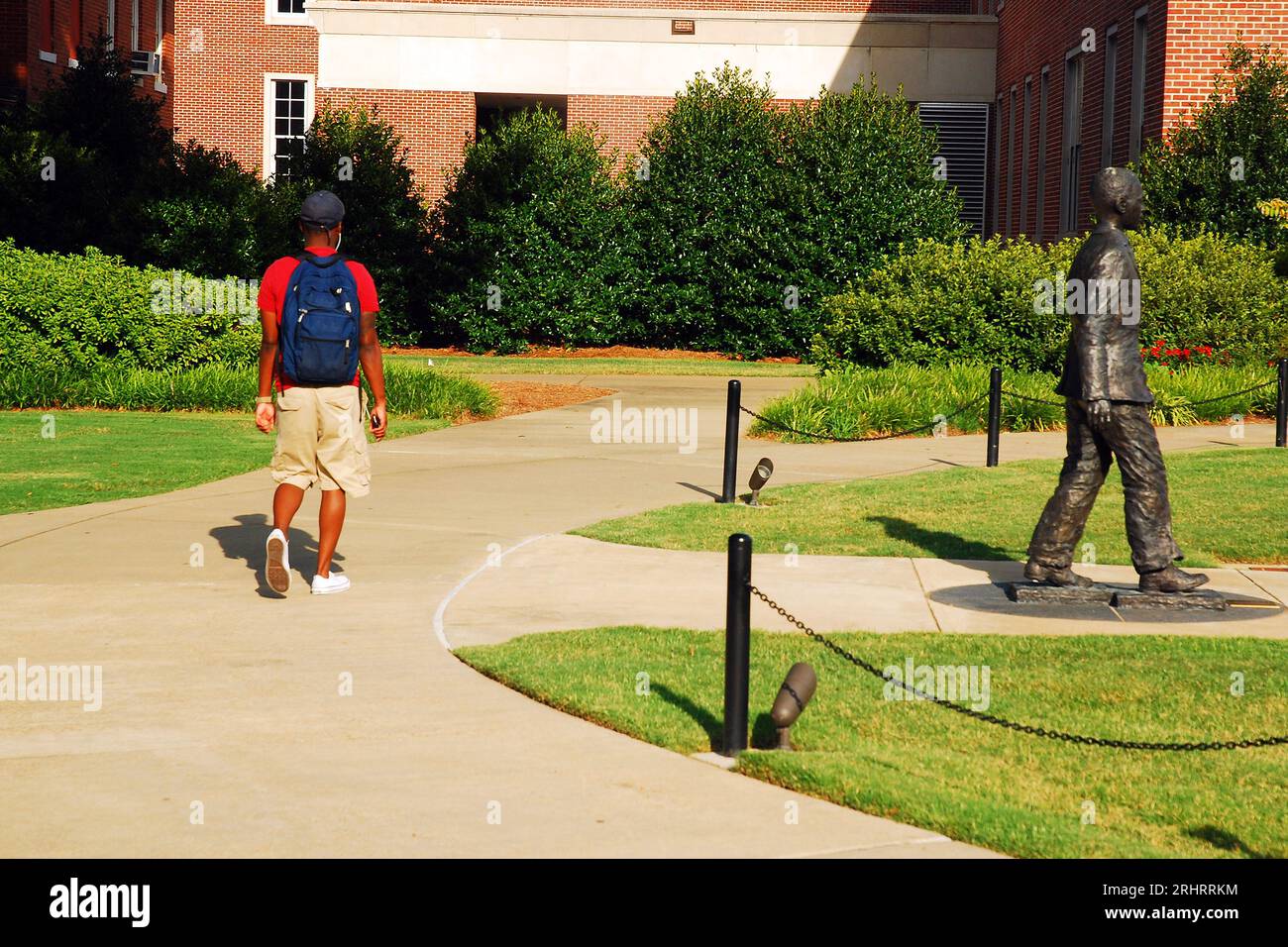 Uno studente afro-americano cammina accanto al James Meredith Monument, onorando il primo studente nero a frequentare l'Università del Mississippi. Foto Stock