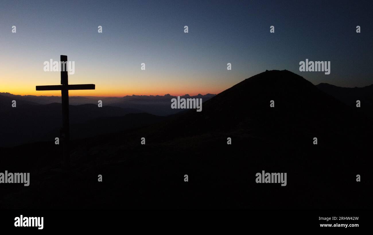 Sonnenaufgang hoch auf den Bergen - Sonnenaufgang am Gipfelkreuz Foto Stock