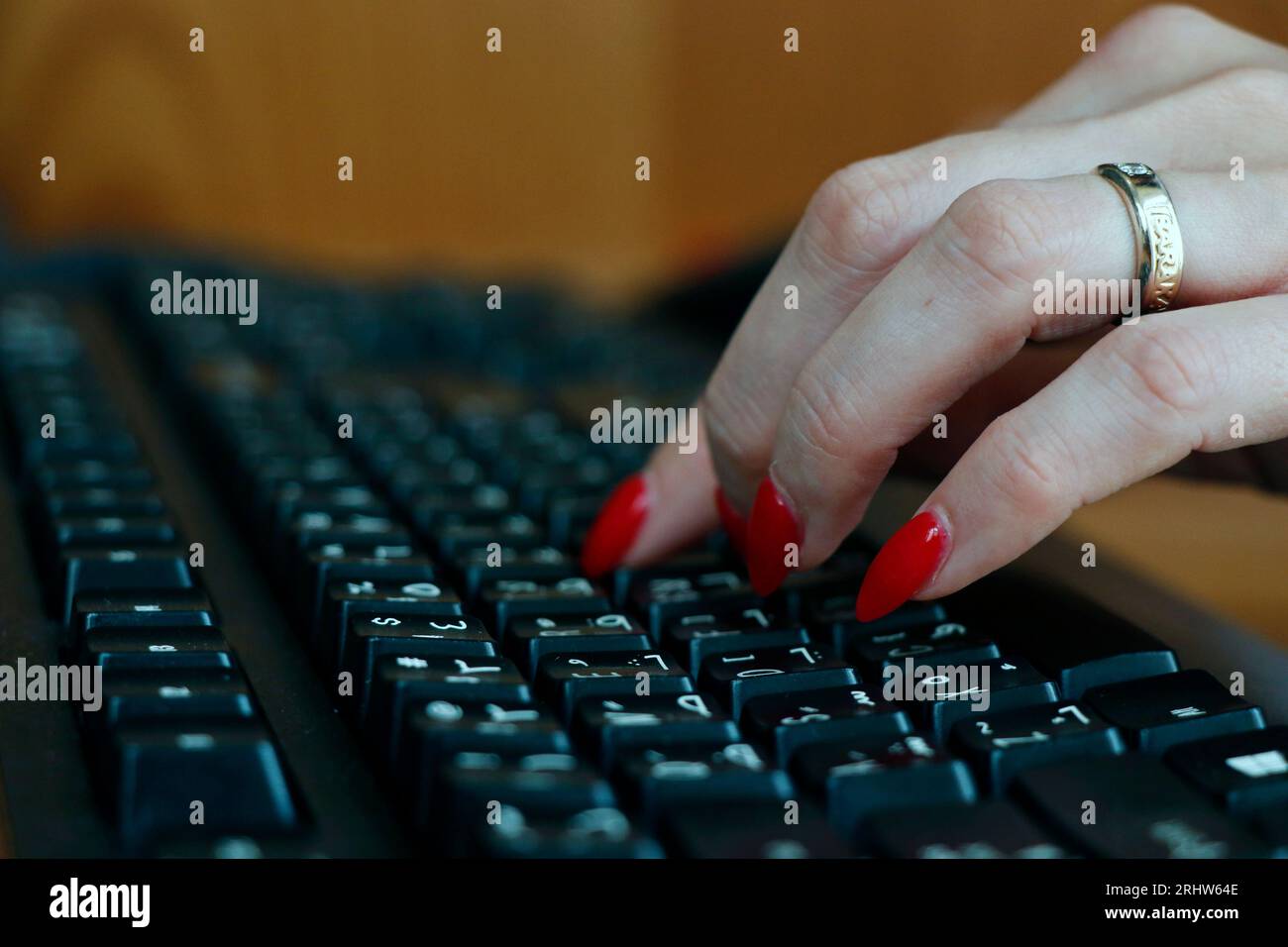 donna lavoratrice in ufficio che si è avvicinata al computer o alla tastiera nera del computer portatile Foto Stock