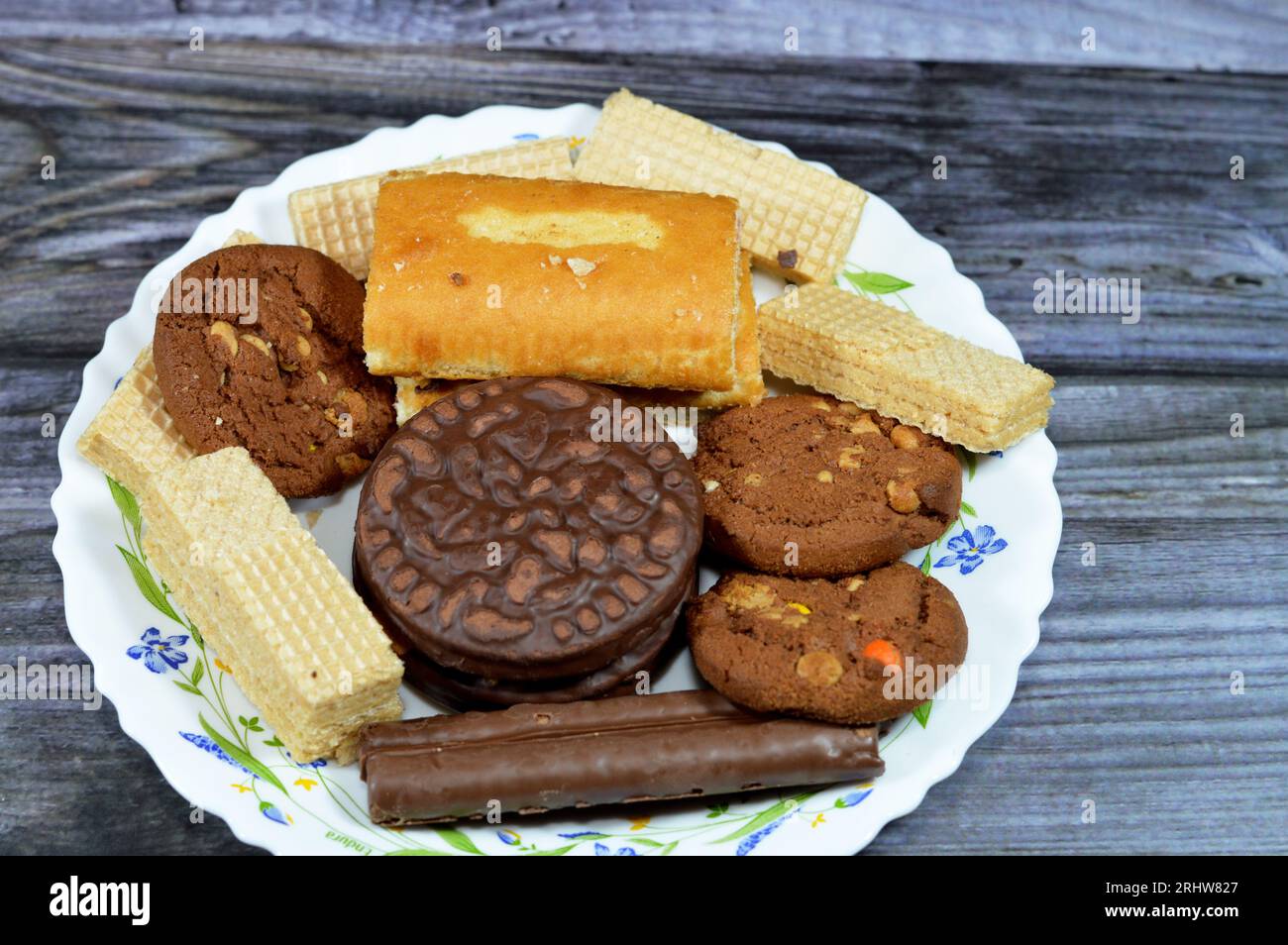 Un piatto di caramelle con bastoncini di cioccolato, cialde croccanti con ripieno di crema di cioccolato, cialde croccanti biscotti ripieni di vaniglia, panini svizzeri ripieni Foto Stock