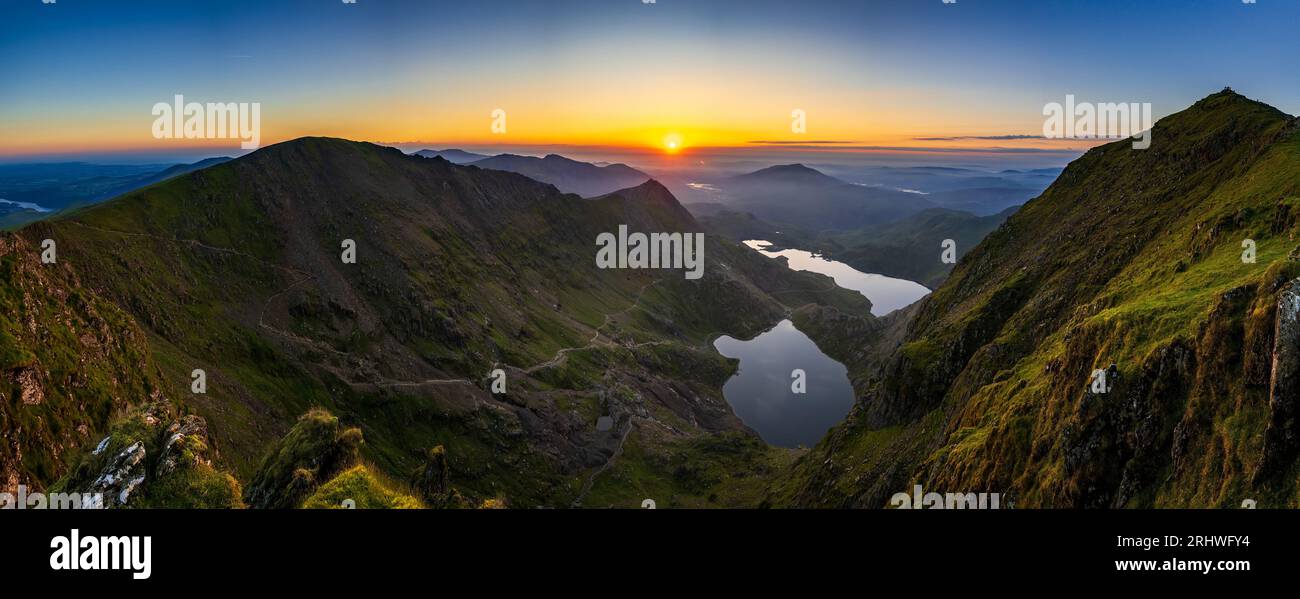 Snowdonia. La vista del sorgere del sole dalla cima del Monte Snowdon, Yr Wyddfa, guardando ad est verso il lago Glaslyn (la macchina fotografica più vicina) e Llyn Llydaw dietro. Foto Stock