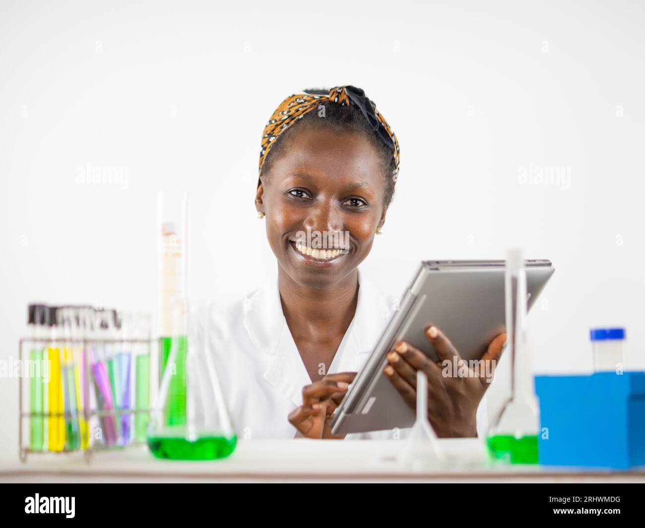 Giovane scienziata che usa il tablet in un laboratorio che guarda la macchina fotografica Foto Stock
