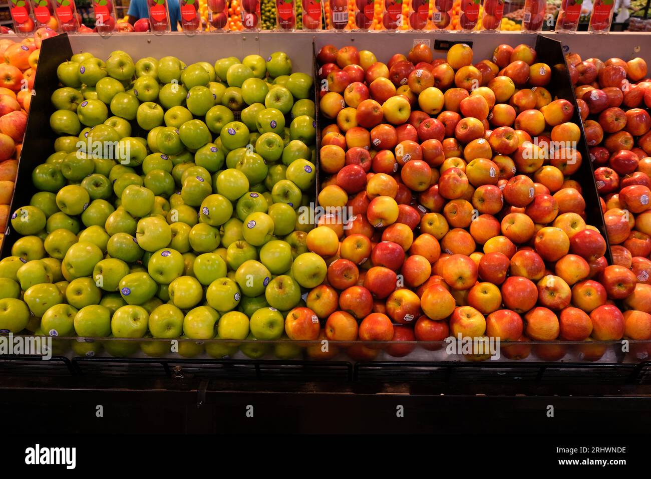 Mele verdi e rosse in esposizione in un supermercato Foto Stock