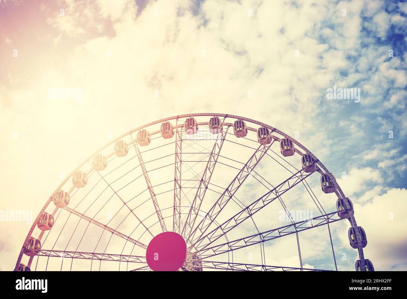 Immagine a colori di una ruota panoramica contro il cielo, con tonalità di colore applicata. Foto Stock