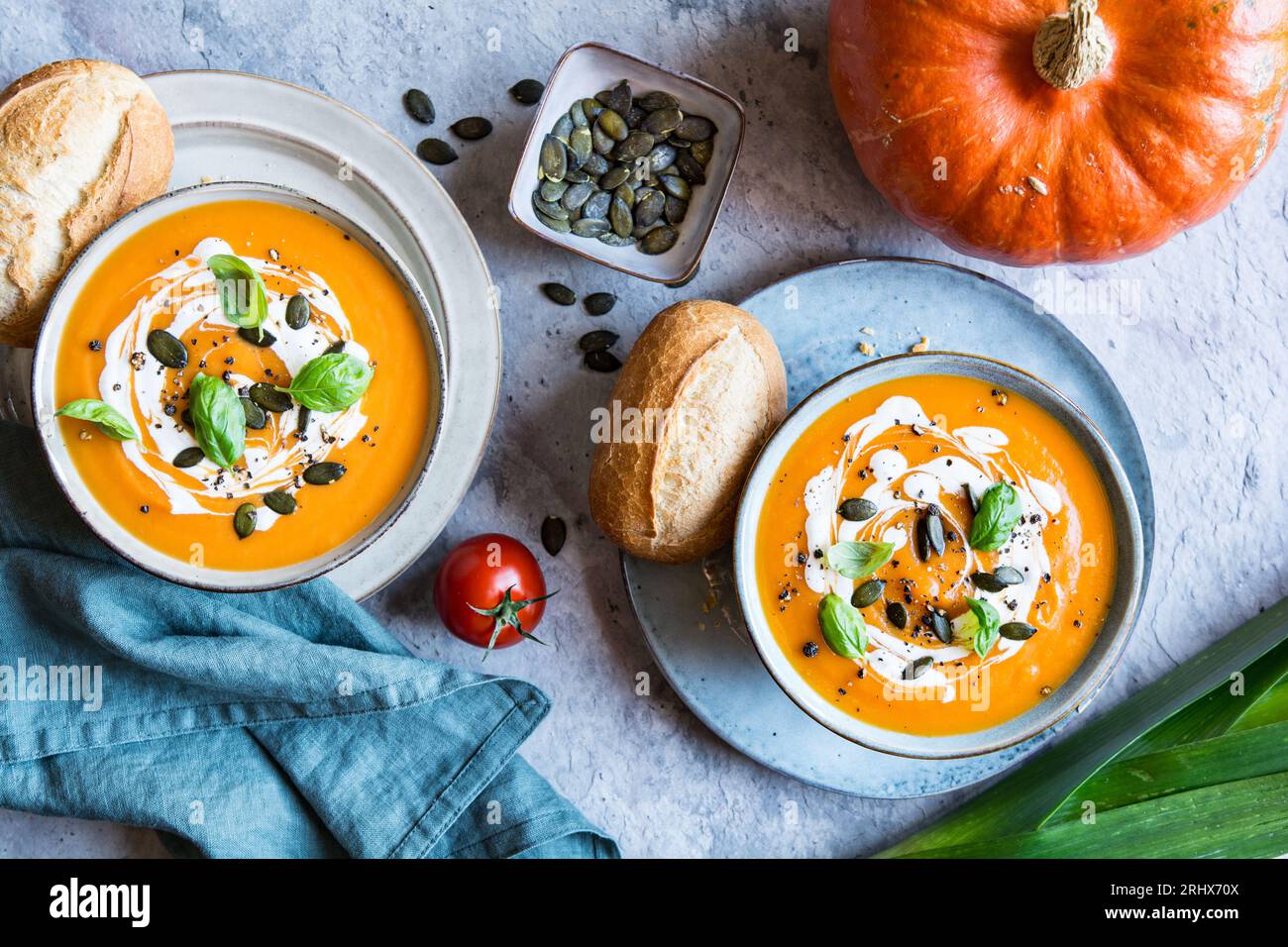 Zuppa vegetariana con crema di zucca e pomodoro condita con panna acida, semi di zucca e basilico Foto Stock