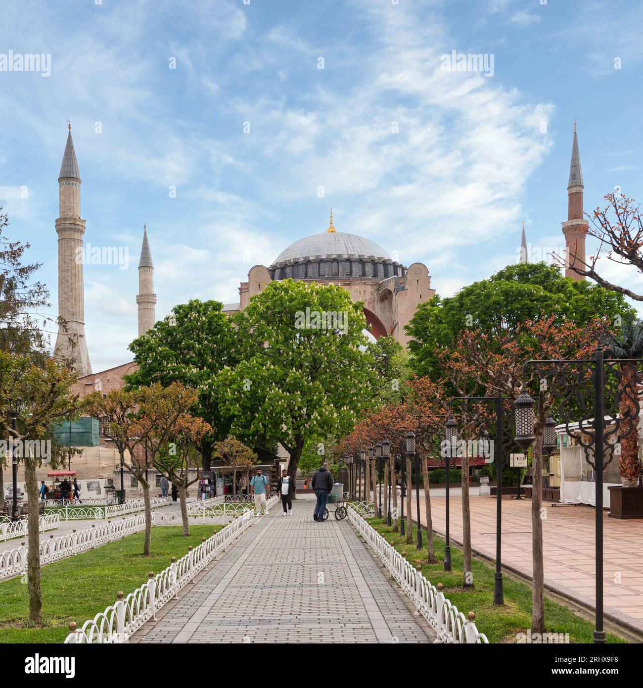 Istanbul, Turchia - 11 maggio 2023: Gruppo di persone che camminano lungo un marciapiede di fronte a Santa Sofia, un sito patrimonio dell'umanità dell'UNESCO. L'Hagia Sophia è un'ex chiesa, museo e ora moschea Foto Stock