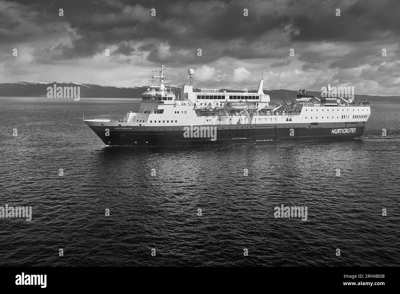 Moody Black and White Photo of the Norwegian Hurtigruten Ferry, MS VESTERALEN, Vailing Southbound in the Trondheim Fjord (Trondheimsfjorden), Norvegia Foto Stock