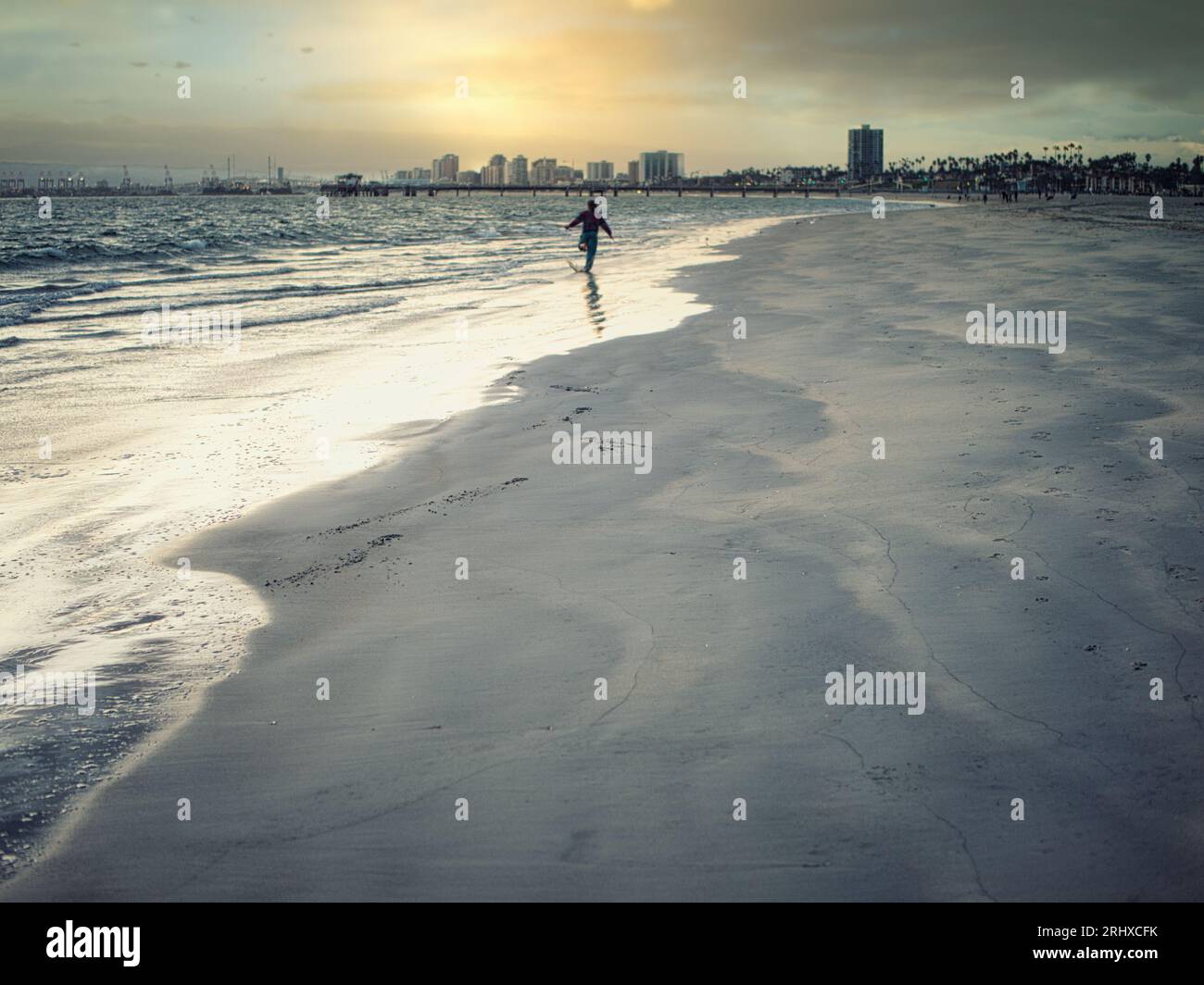 Foto di una persona che si sta godendo una tranquilla passeggiata lungo le splendide spiagge di Los Angeles, California Foto Stock