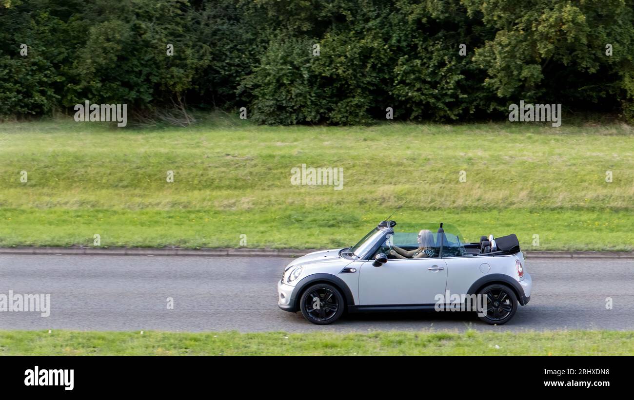 Milton Keynes, Regno Unito - 16 agosto 2023: 2011 R57 Mini Cooper Convertible car che viaggia su una strada inglese Foto Stock