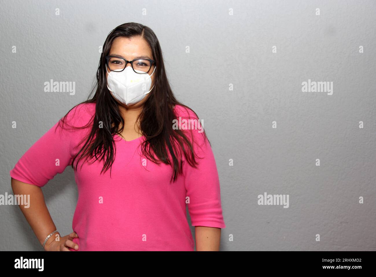 Donna latina adulta con occhiali che indossa maschere facciali per la protezione da Covid-19 a causa della pandemia Foto Stock