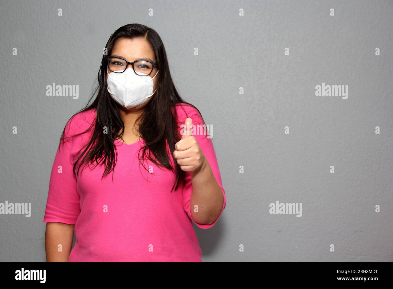Donna latina adulta con occhiali che indossa maschere facciali per la protezione da Covid-19 a causa della pandemia Foto Stock