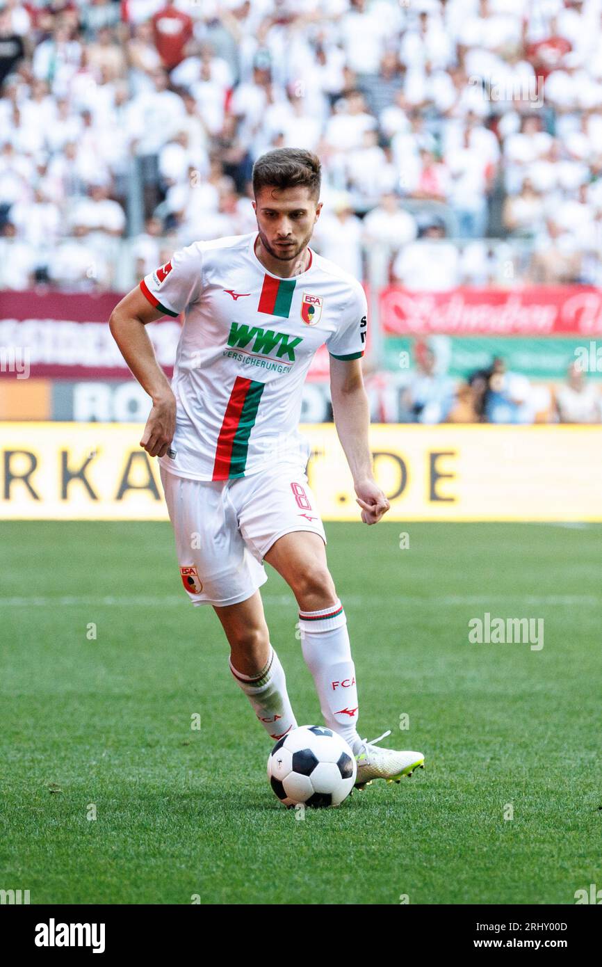 Augusta, Germania. 19 agosto 2023. Calcio: Bundesliga, FC Augsburg - Borussia Mönchengladbach, Matchday 1, WWK Arena. Elvis Rexhbecaj di Augusta gioca la palla. Credito: Matthias Balk/dpa - NOTA IMPORTANTE: conformemente ai requisiti della DFL Deutsche Fußball Liga e della DFB Deutscher Fußball-Bund, è vietato utilizzare o far utilizzare fotografie scattate nello stadio e/o della partita sotto forma di immagini di sequenza e/o serie di foto simili a video./dpa/Alamy Live News Foto Stock