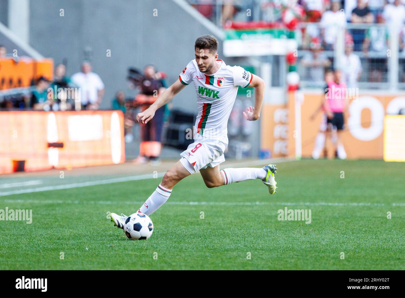 Augusta, Germania. 19 agosto 2023. Calcio: Bundesliga, FC Augsburg - Borussia Mönchengladbach, Matchday 1, WWK Arena. Elvis Rexhbecaj di Augusta gioca la palla. Credito: Matthias Balk/dpa - NOTA IMPORTANTE: conformemente ai requisiti della DFL Deutsche Fußball Liga e della DFB Deutscher Fußball-Bund, è vietato utilizzare o far utilizzare fotografie scattate nello stadio e/o della partita sotto forma di immagini di sequenza e/o serie di foto simili a video./dpa/Alamy Live News Foto Stock