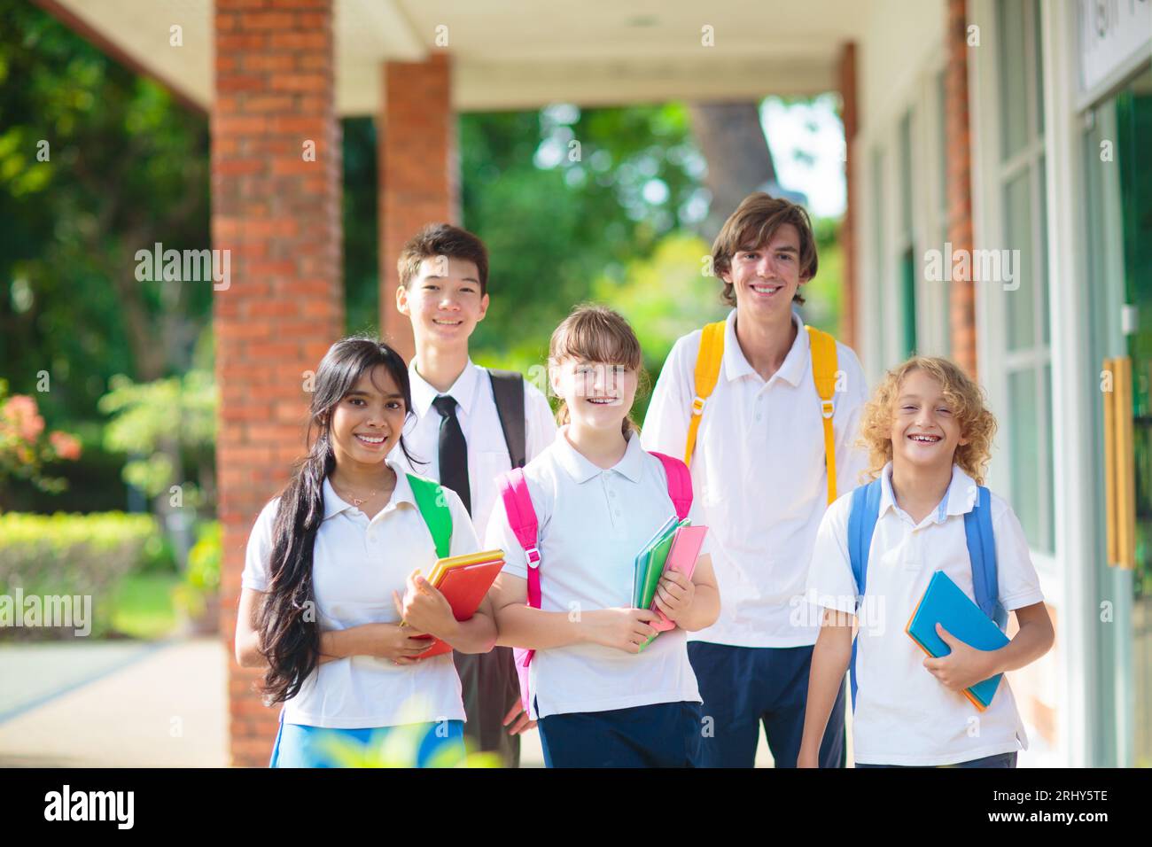 I ragazzi tornano a scuola. Gruppo interrazziale di bambini di età mista il primo giorno del nuovo anno accademico. Adolescente in classe. Foto Stock