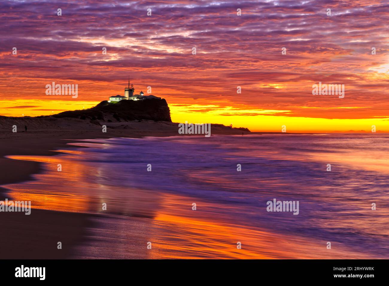 Alba colorata e luminosa sulla costa pacifica dell'Australia nella città di Newcastle, Nobbys Head e la spiaggia. Foto Stock