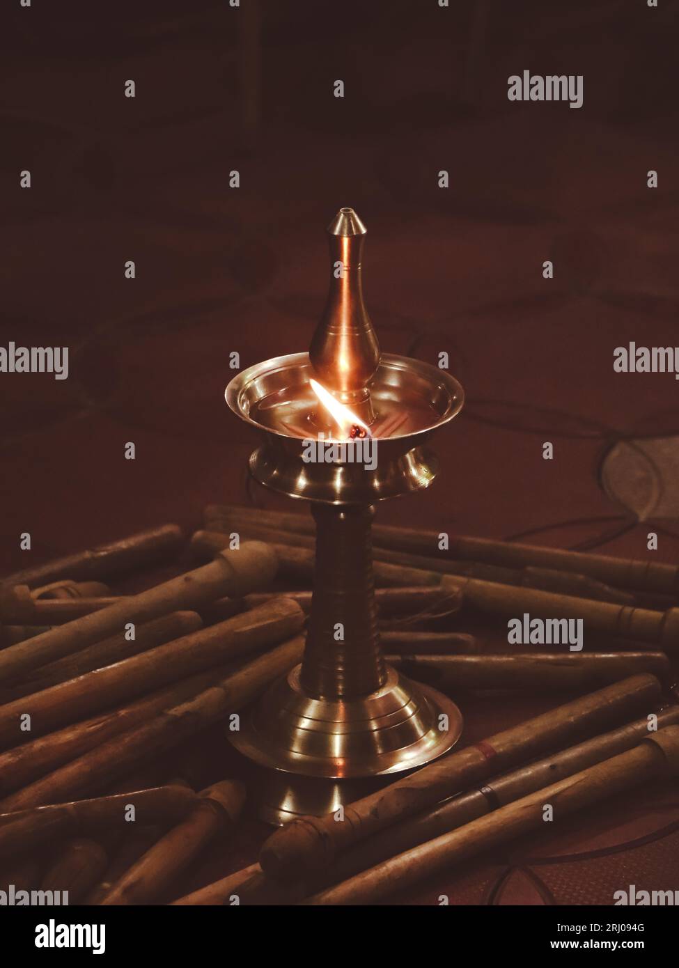 una tradizionale lampada diya a olio d'ottone con una fiamma ardente durante una pooja religiosa e un festival per la decorazione notturna in india Foto Stock