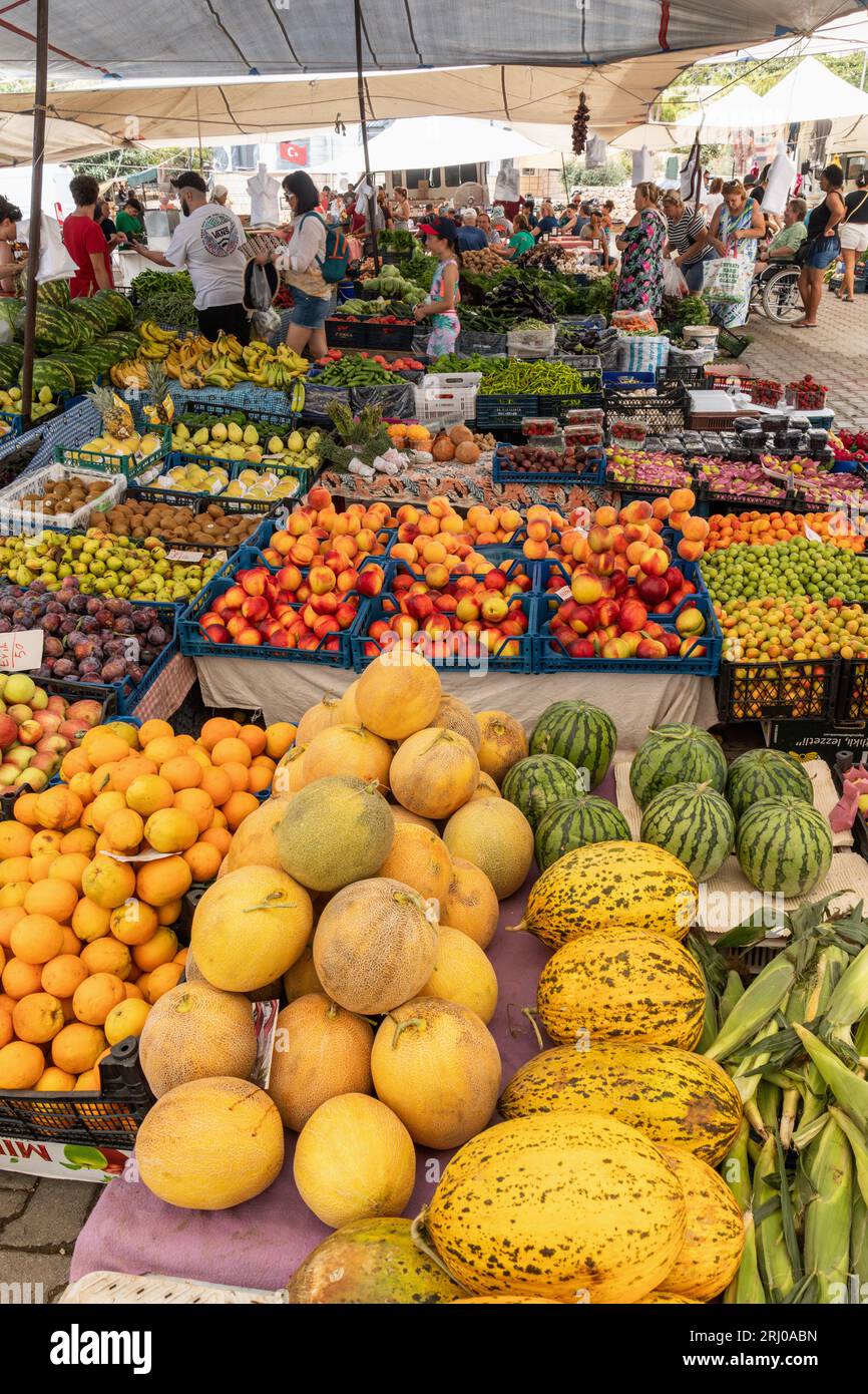 Venditori ambulanti che vendono un assortimento di frutta e verdura fresca nelle loro bancarelle nel mercato turco locale di Kalkan, Kalkan, Turchia Foto Stock