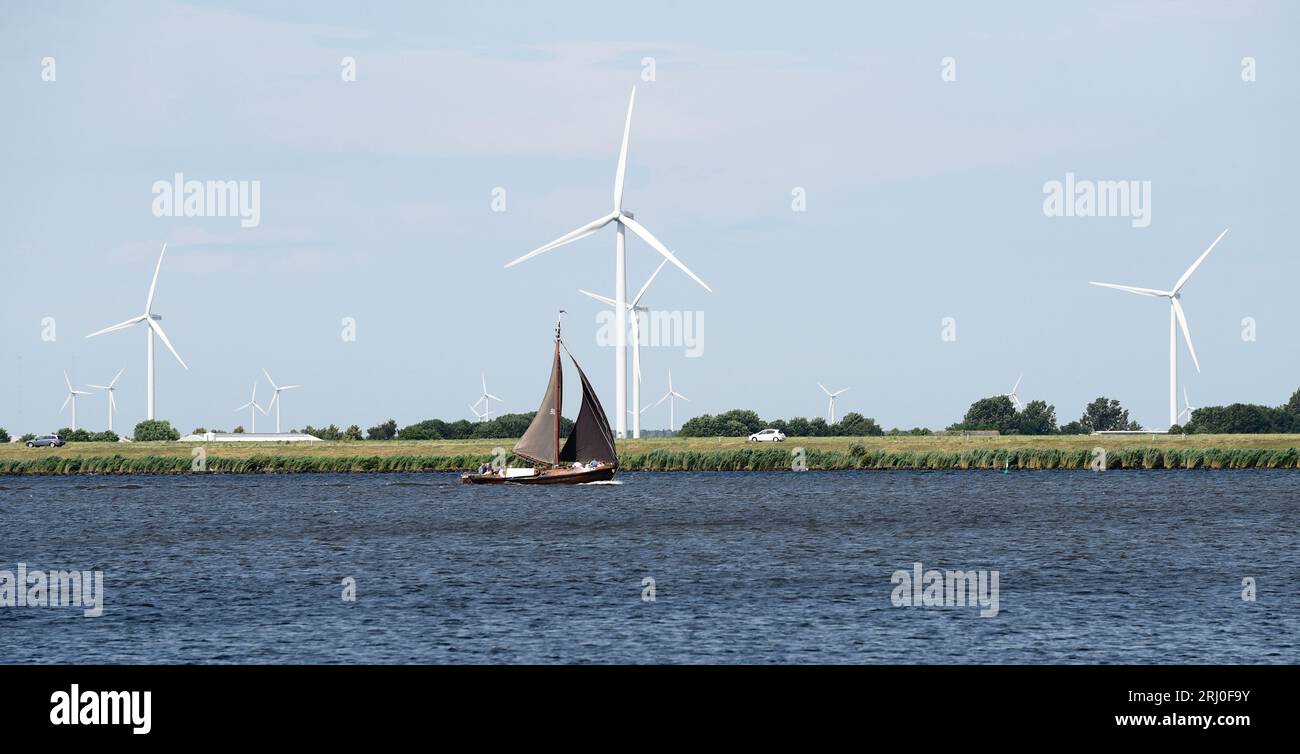 Turbine eoliche e barca a vela di passaggio, un fondo piatto, Eemmeer vicino a Spakenburg Foto Stock