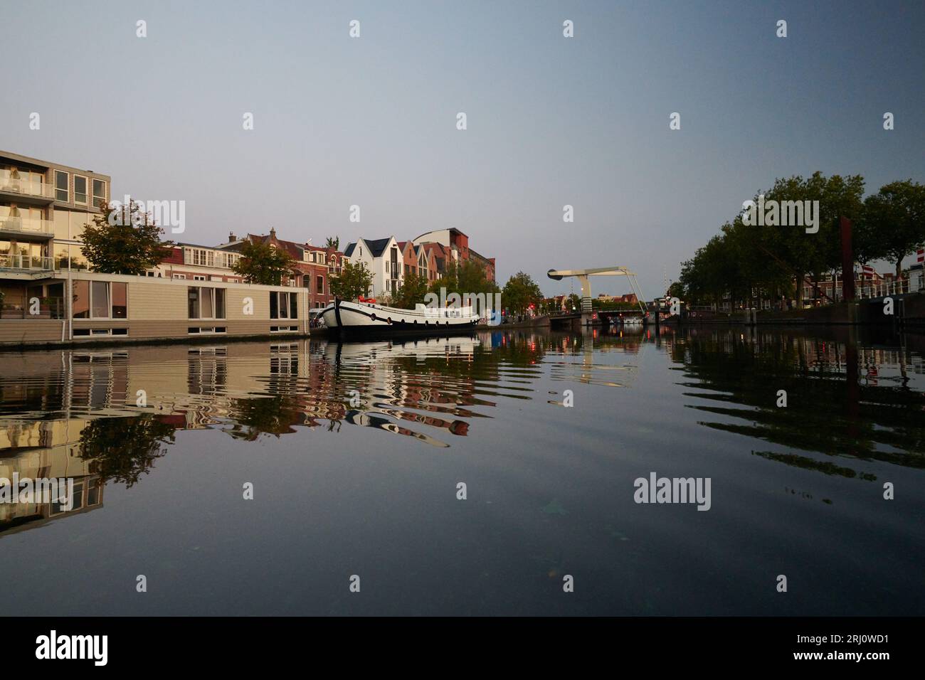 Barche tradizionali olandesi attraccate lungo il fiume nel centro della città di Haarlem Foto Stock