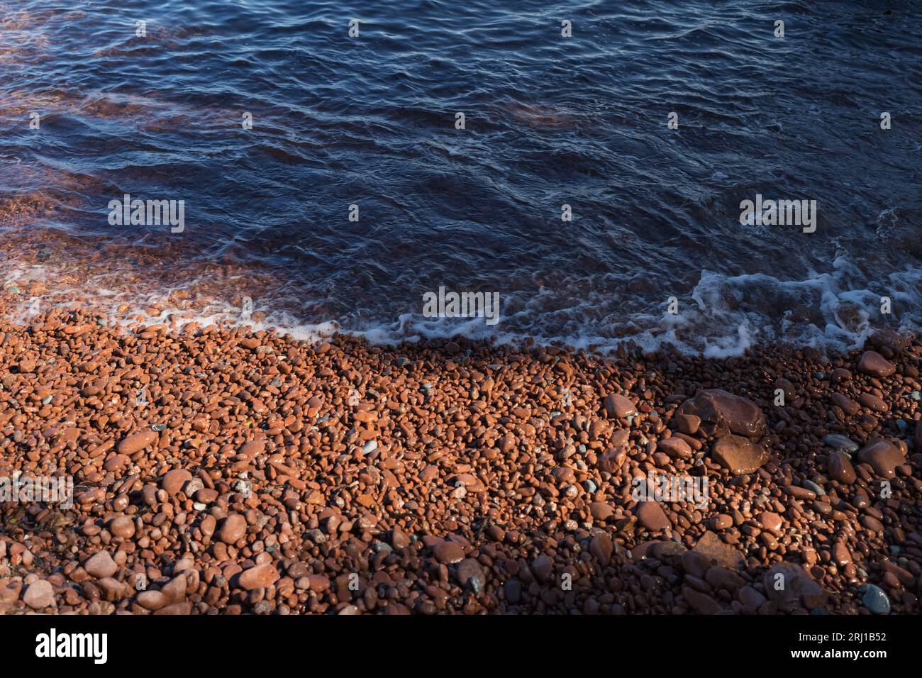 Spiaggia della Costa Azzurra con ciottoli rossi, contenuti di viaggio Foto Stock