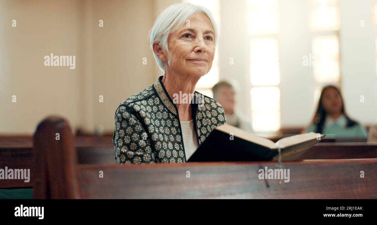 Bibbia, religione e una donna anziana in una chiesa per un sermone sulla fede o sul credo cristiano mentre si siede in una pila. Preghiera, culto o lettura con un Foto Stock