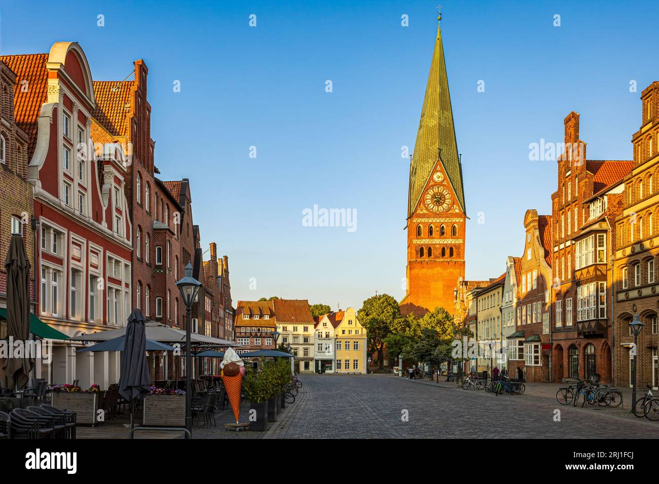 Per le strade di Luneburg con la guglia leggermente inclinata della chiesa di San John sullo sfondo. La foto è stata scattata il 5 giugno 2023 a Lun Foto Stock