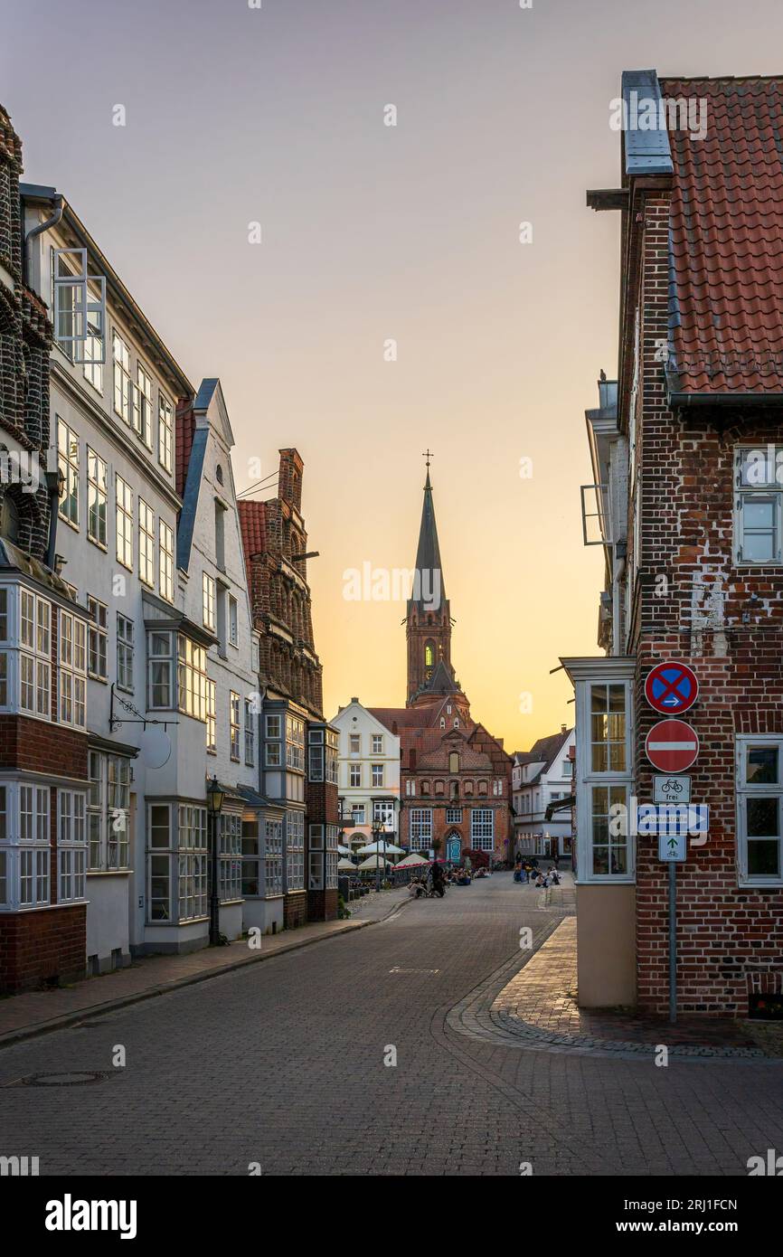 Sulle strade di Luneburg con la torre principale della chiesa di San Nicolai sullo sfondo. La foto è stata scattata il 5 giugno 2023 a Luneburg o. Foto Stock