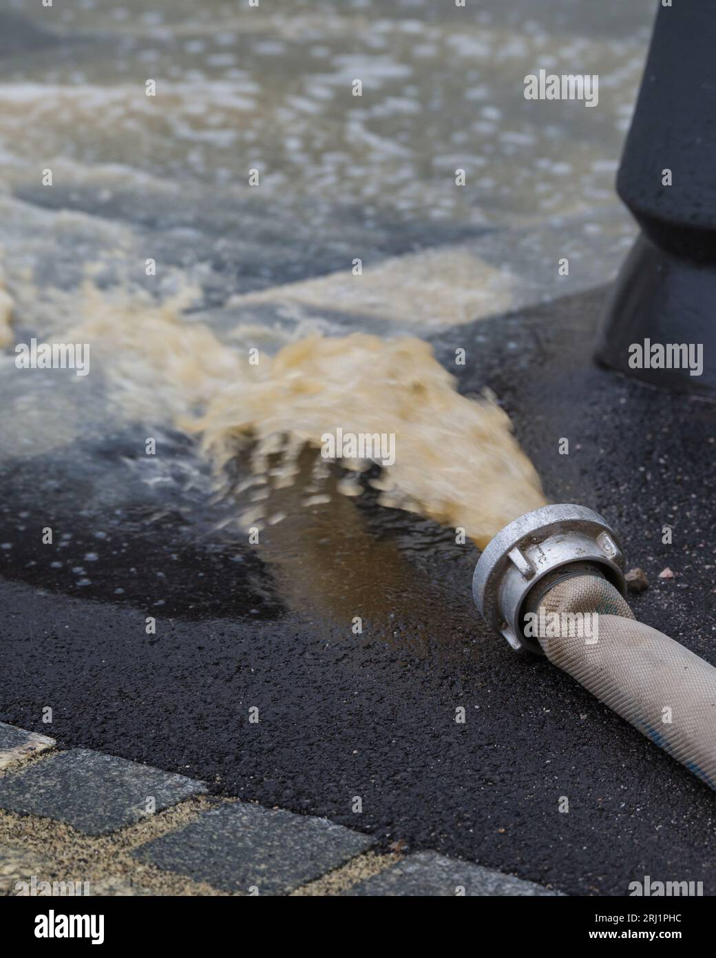 Pompa dell'acqua in caso di inondazioni nelle strade della città dopo una forte pioggia. Grave disastro meteorologico. Foto Stock