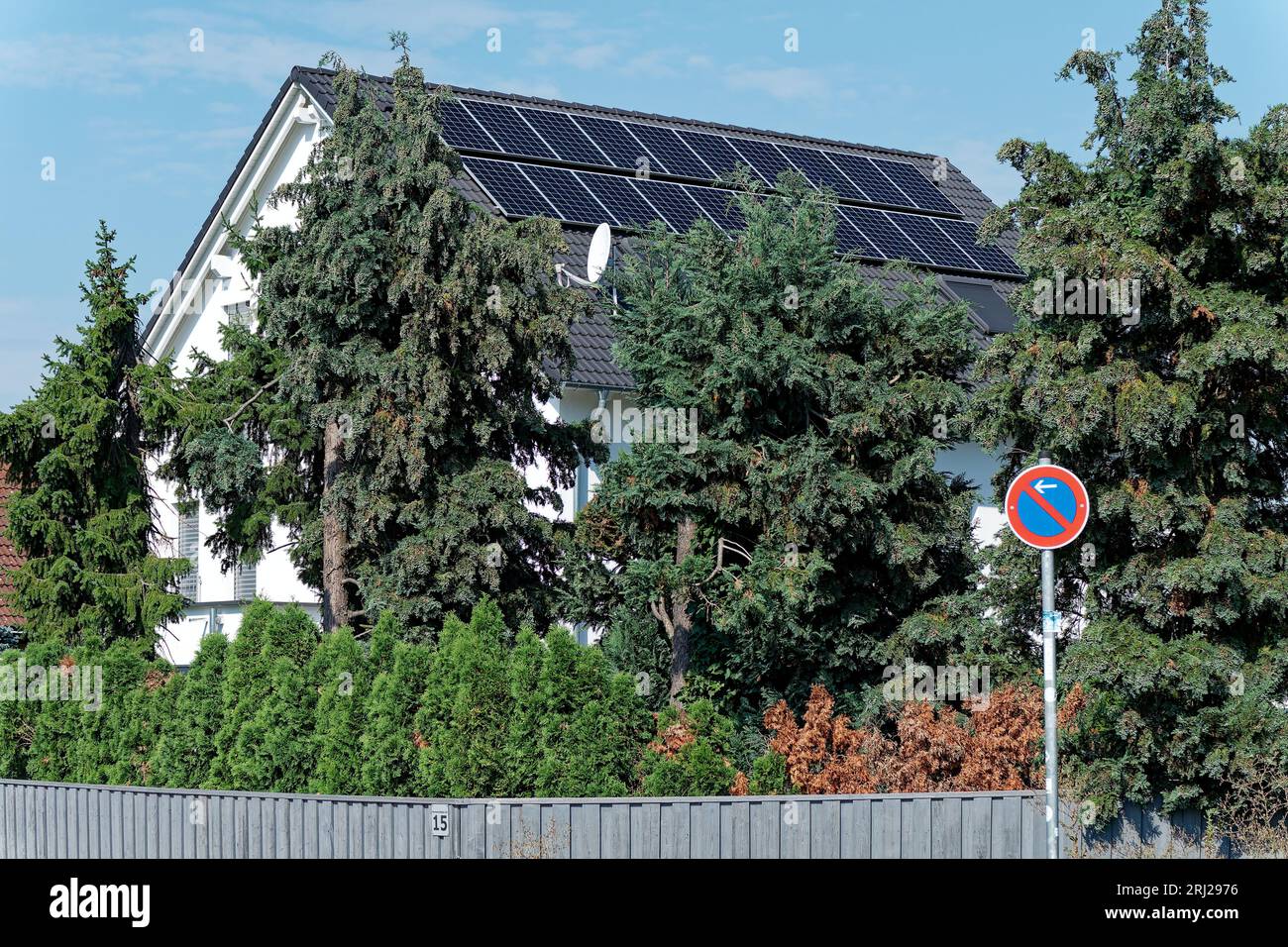 Aumento dei costi dell'elettricità e autoproduzione di elettricità, tetto della casa con elementi fotovoltaici Foto Stock