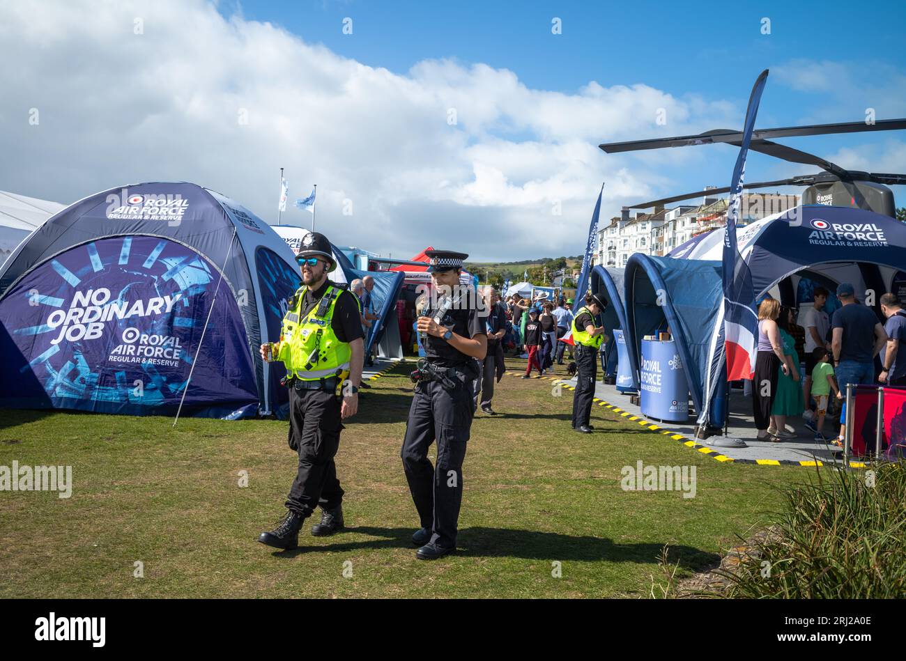 Due poliziotti camminano attraverso la mostra militare accanto all'annuale Eastbourne Airbourne, un airshow internazionale. Lo spettacolo dura quattro giorni ciascuno Foto Stock