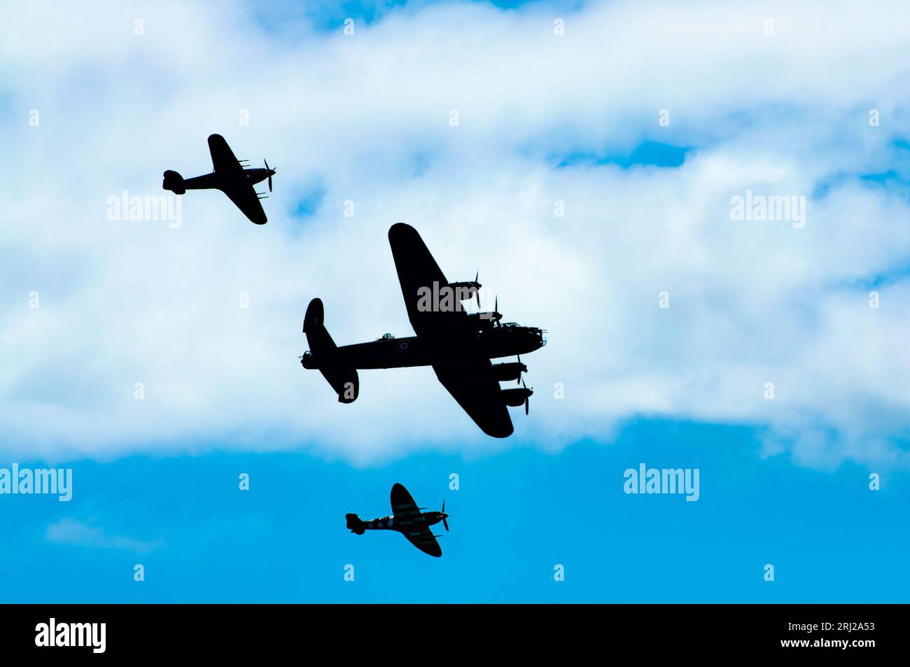Il Battle of Britain Memorial Flight, che comprende Lancaster, Spitfire e Hurricane dell'epoca della seconda guerra mondiale, è visibile in silhouette mentre sorvolano il lungomare di Foto Stock