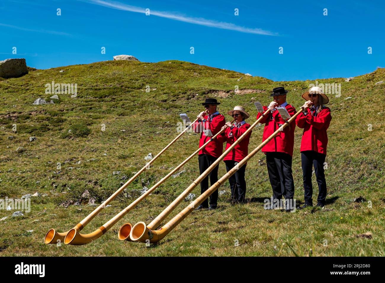 Julierpass (Svizzera) 08/19/2023: Un gruppo di musicisti tipici della Svizzera che suonano il corno svizzero uno strumento tipico delle alpi svizzere su una A. Foto Stock