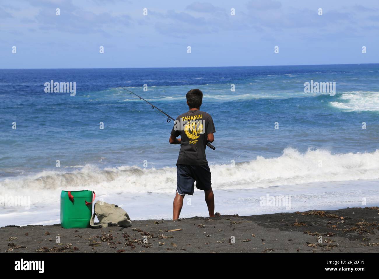 pêche à la ligne sur la plage de Sable noir volcanique de Papara à Tahiti en Polynésie francaise. Cette plage de Taharuu est connue pour ses belles va Foto Stock