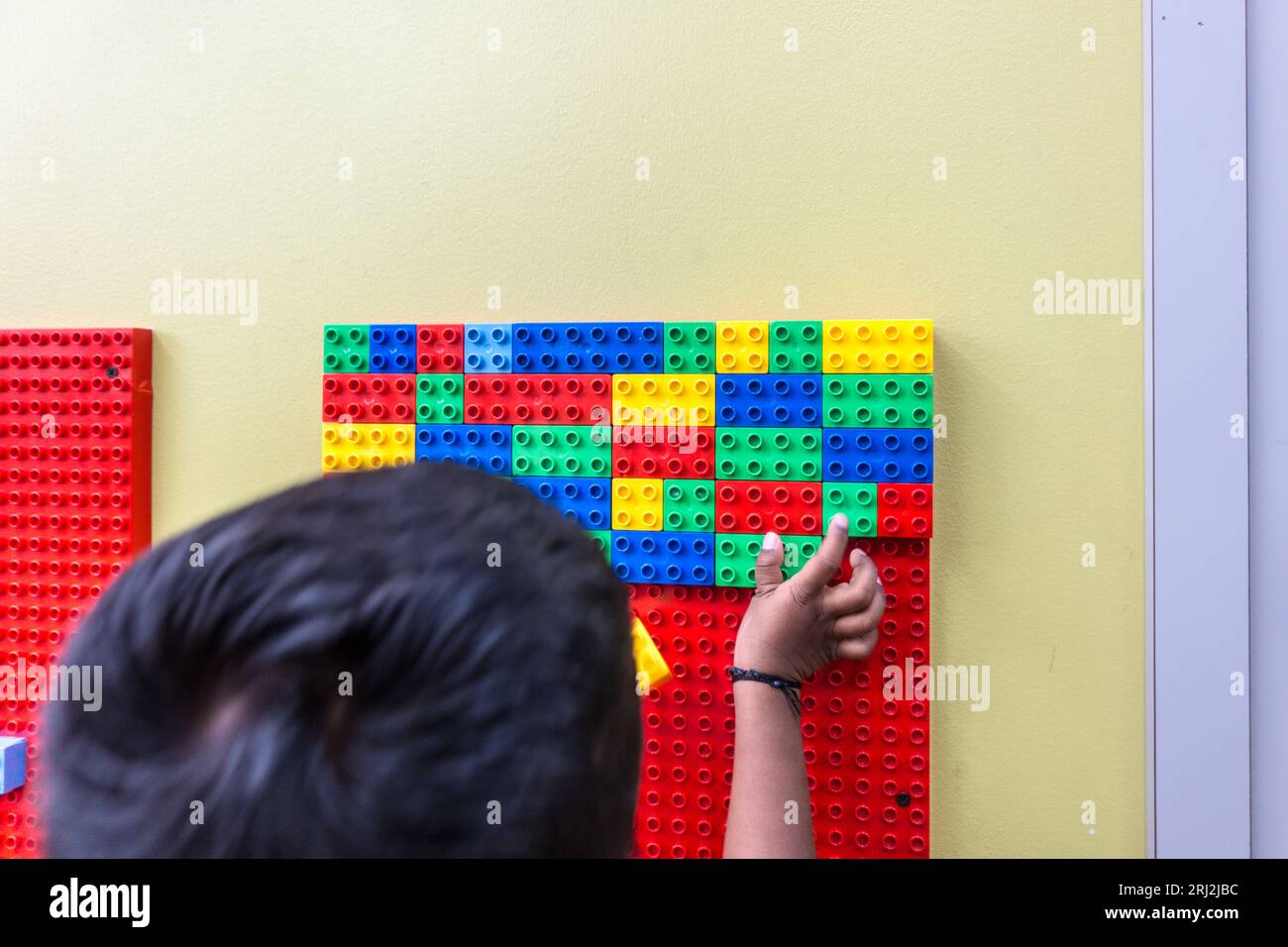 Bambini di 5 anni che giocano con i blocchi lego in una biblioteca pubblica Foto Stock