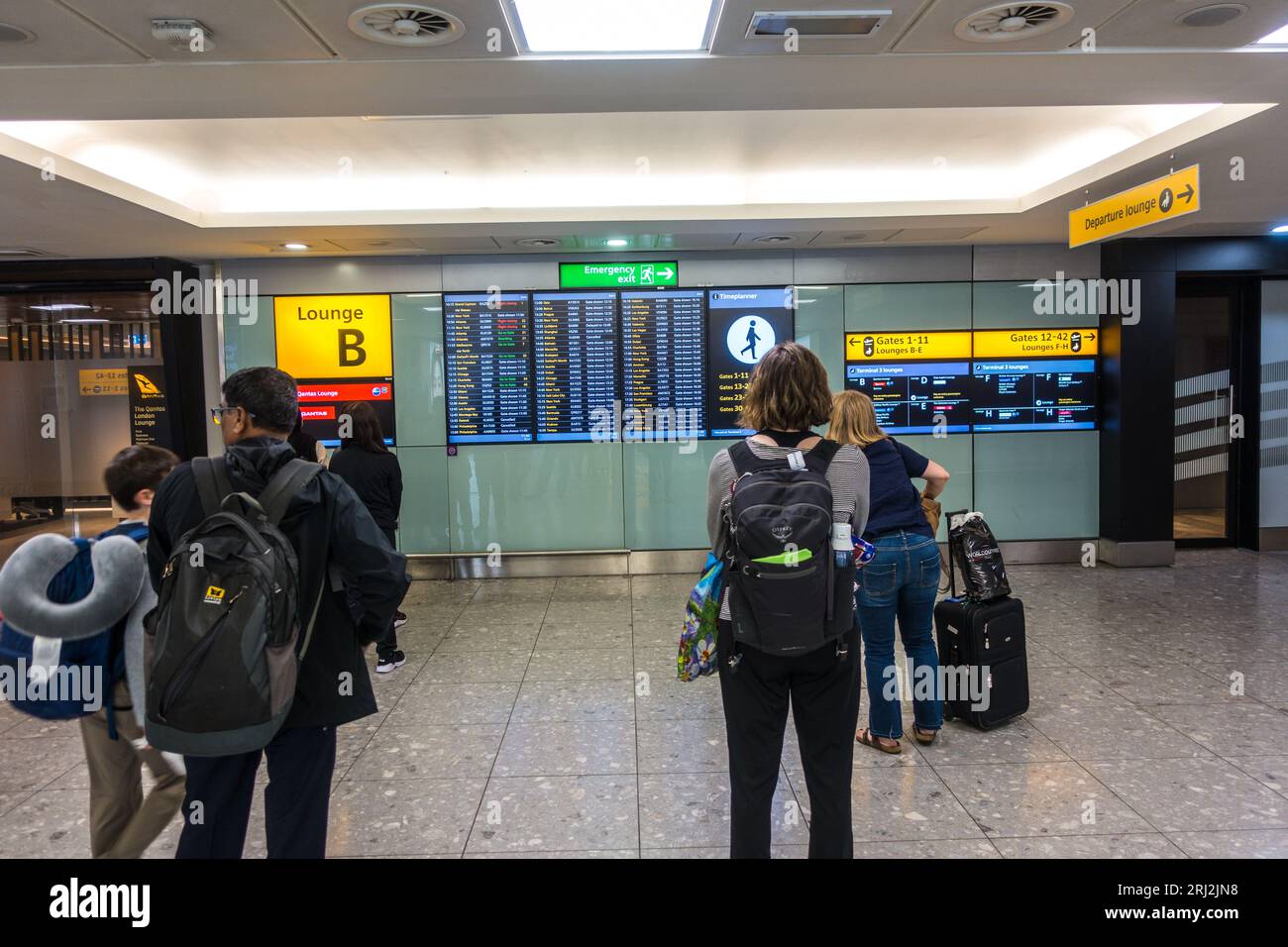 I passeggeri dei viaggi aerei controllano i cancelli di volo del terminal 3 di Heathrow Foto Stock